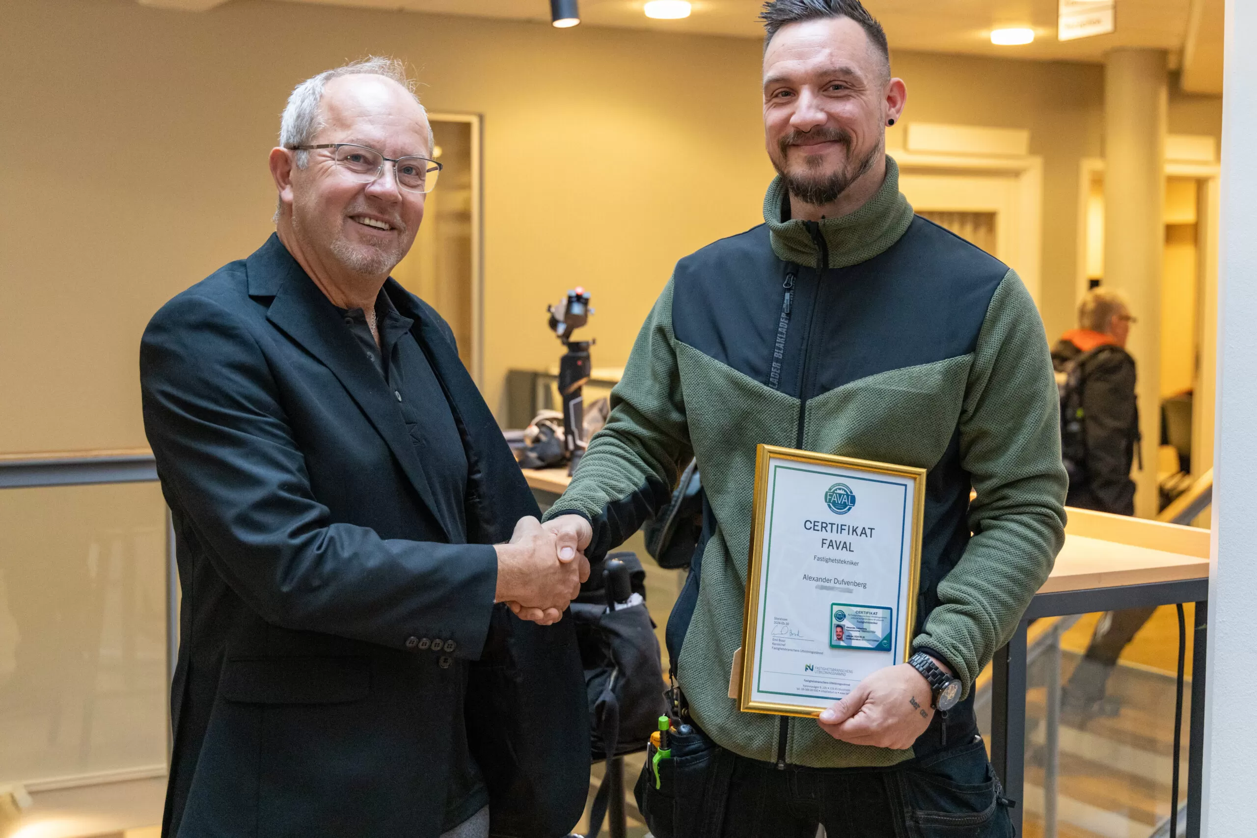 Testledare som gratulerar en medarbetare som har fått sitt certifikat